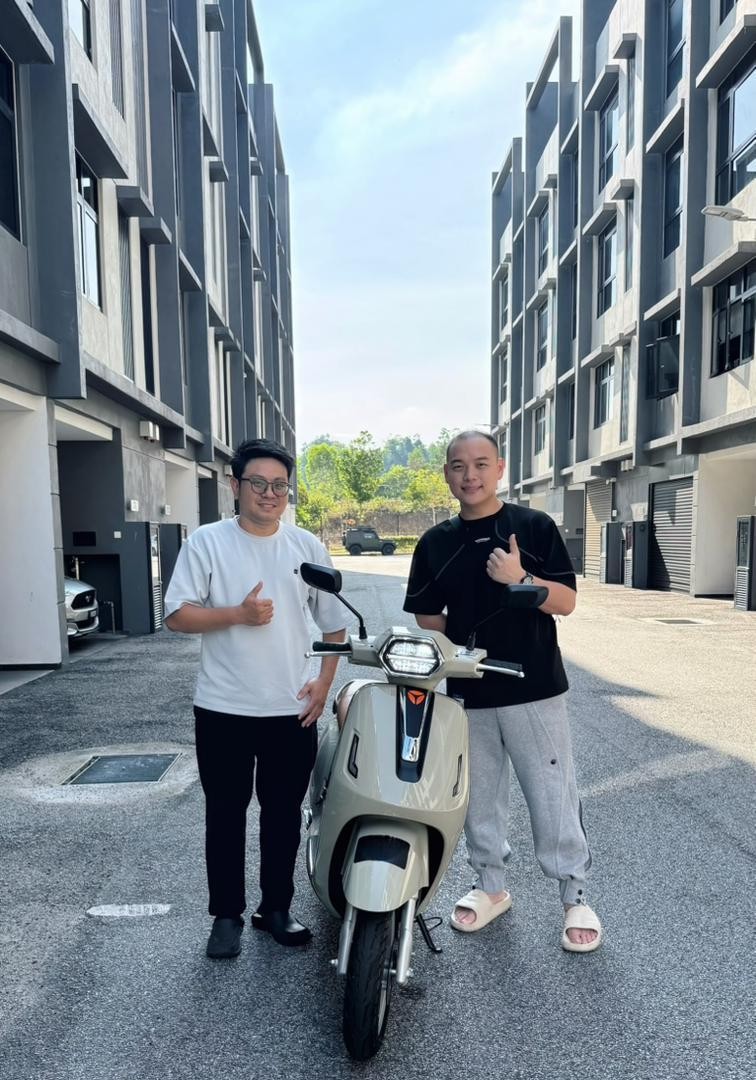 Hok Hing Motor 公司简介中,两名男子在户外与一辆浅色摩托车合照